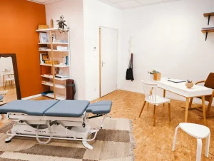 Box individuel pour pratiquer l'ostéopathie. Dans la pièce, il y a un bureau, une bibliothèque, une table de massage.