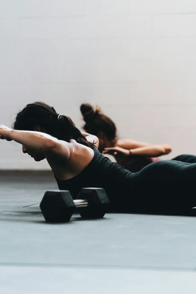 Une sportive en legging effectue des exercices de gainage de dos (superman)