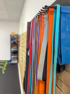 Un rack avec de nombreux élastiques, placé sur un des murs du plateau technique du cabinet.