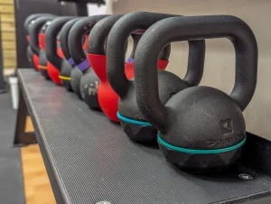 Un rack avec de nombreux kettlebells sur le plateau technique du cabinet.