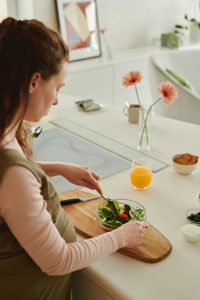 Une femme enceinte se prépare un repas sain.